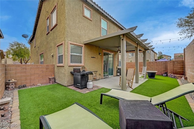 rear view of house with a patio area, a fenced backyard, a lawn, and stucco siding