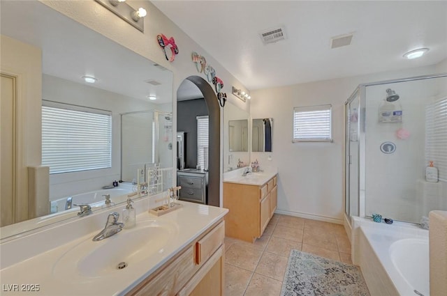 bathroom with visible vents, a sink, a bath, and tile patterned floors