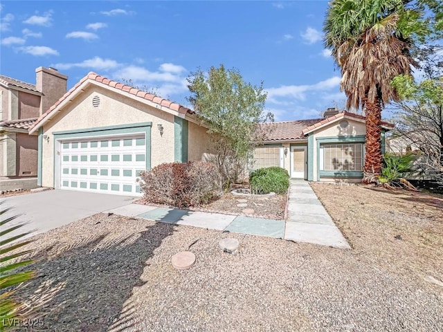 view of front of house with a garage, a tile roof, concrete driveway, stucco siding, and a chimney