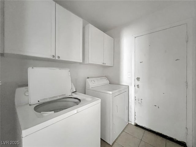 laundry area with light tile patterned floors, separate washer and dryer, and cabinet space