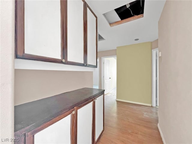 hallway featuring light wood-style floors and baseboards