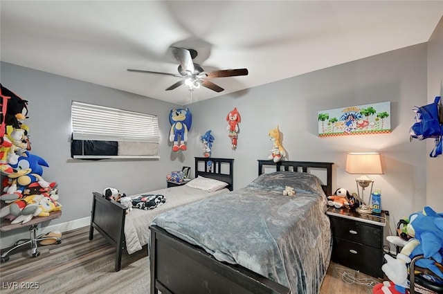 bedroom with wood finished floors, a ceiling fan, and baseboards