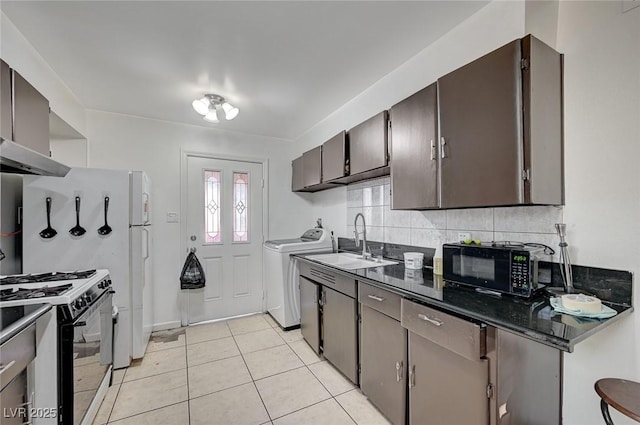 kitchen featuring washer / dryer, decorative backsplash, black microwave, a sink, and gas stove