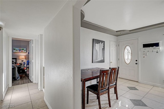 foyer entrance with light tile patterned floors and baseboards