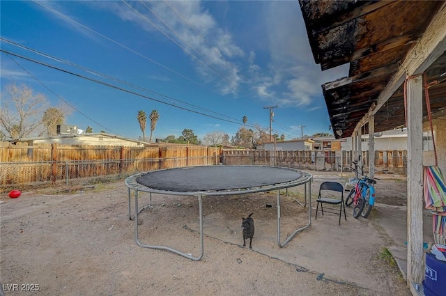 view of patio with a trampoline and a fenced backyard