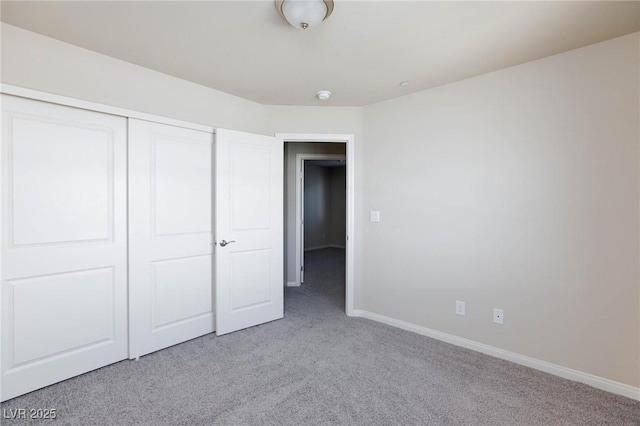 unfurnished bedroom with a closet, carpet flooring, and baseboards