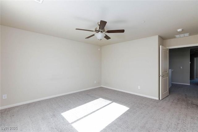 carpeted spare room with visible vents, ceiling fan, and baseboards