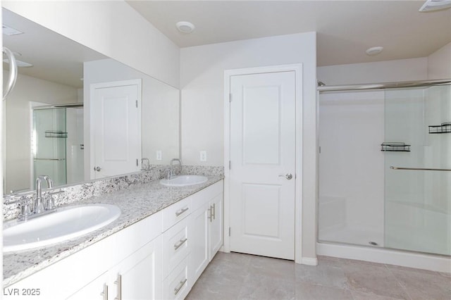 full bath featuring a stall shower, a sink, and double vanity