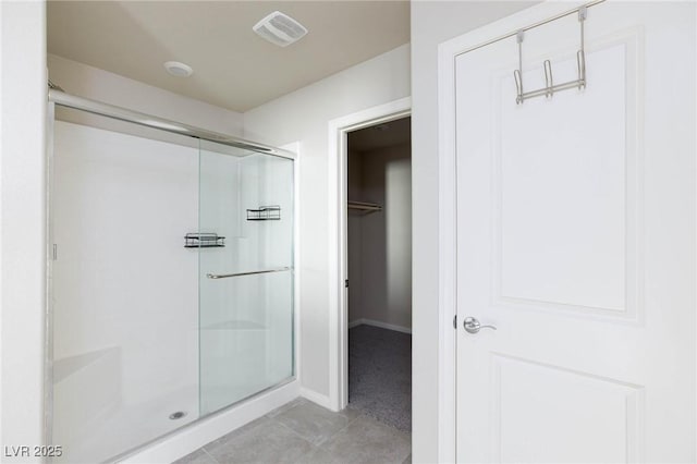 full bath featuring a stall shower, baseboards, visible vents, and tile patterned flooring