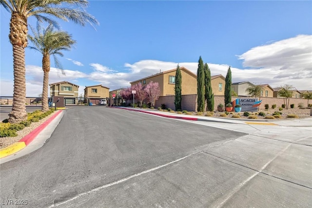 view of road featuring sidewalks, a residential view, a gate, and curbs