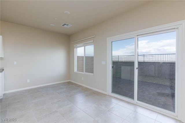 spare room with light tile patterned floors, baseboards, and visible vents