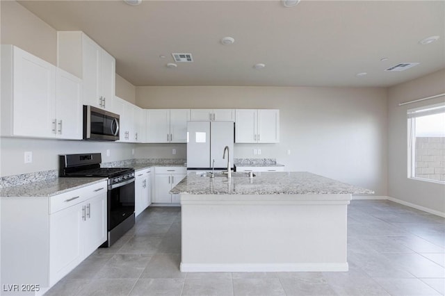 kitchen featuring stainless steel appliances, an island with sink, a sink, and visible vents