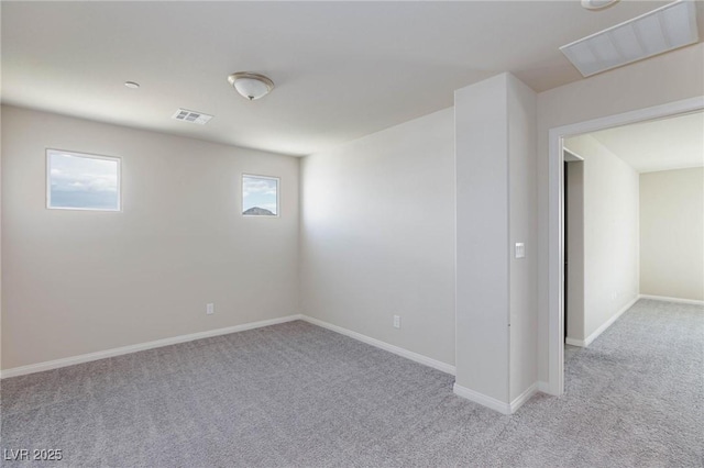 carpeted spare room featuring baseboards and visible vents