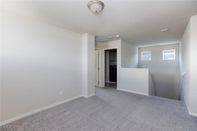 carpeted spare room featuring baseboards