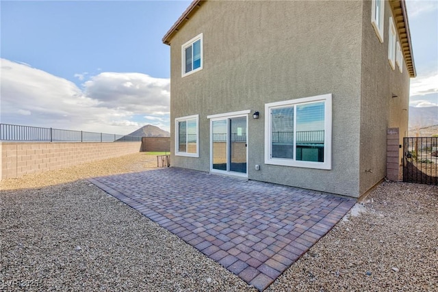 back of house featuring a patio area, a fenced backyard, and stucco siding