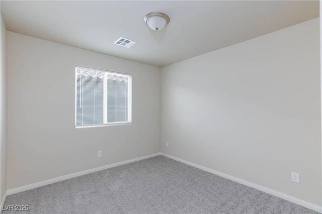 spare room with carpet floors, visible vents, and baseboards