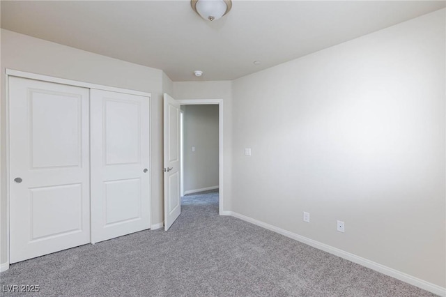 unfurnished bedroom with a closet, baseboards, and carpet flooring