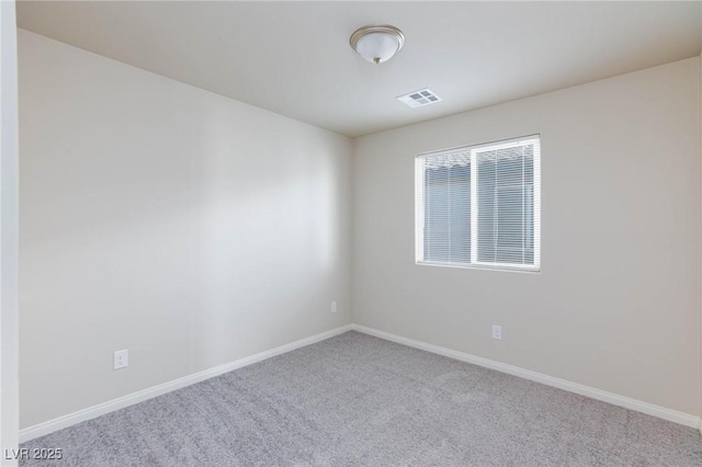 spare room featuring carpet, visible vents, and baseboards