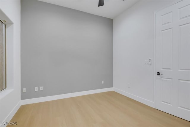 empty room with baseboards, a ceiling fan, and light wood-style floors