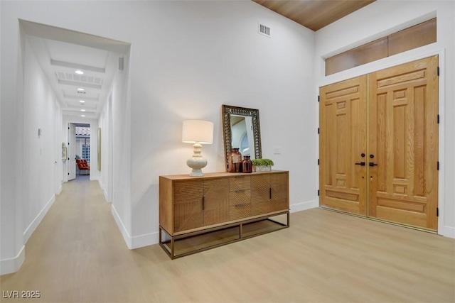 entrance foyer with baseboards, visible vents, and wood finished floors