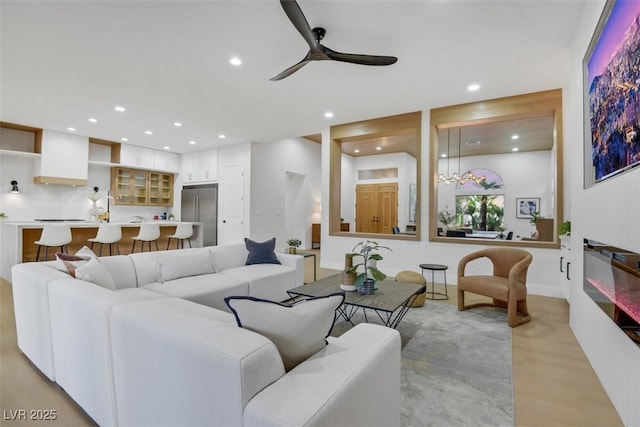 living room with light wood-style floors, a ceiling fan, and recessed lighting