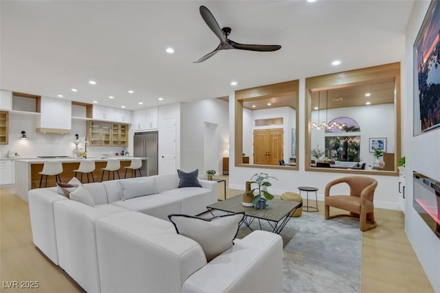 living area featuring a ceiling fan, recessed lighting, and a large fireplace