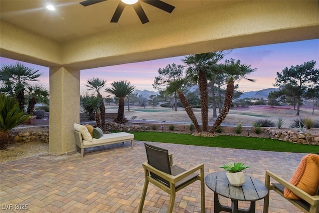 view of patio with ceiling fan and a mountain view