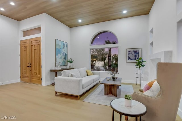 living area with light wood-style floors, recessed lighting, wood ceiling, and baseboards