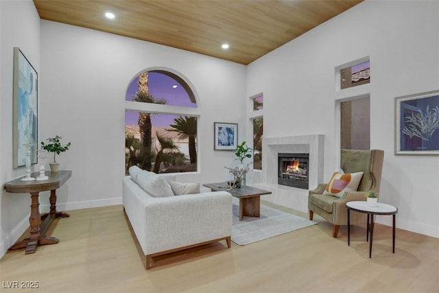 living room with wood finished floors, a high end fireplace, wood ceiling, and recessed lighting