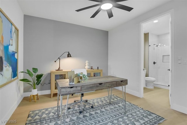 home office featuring light wood-style floors, a ceiling fan, and baseboards