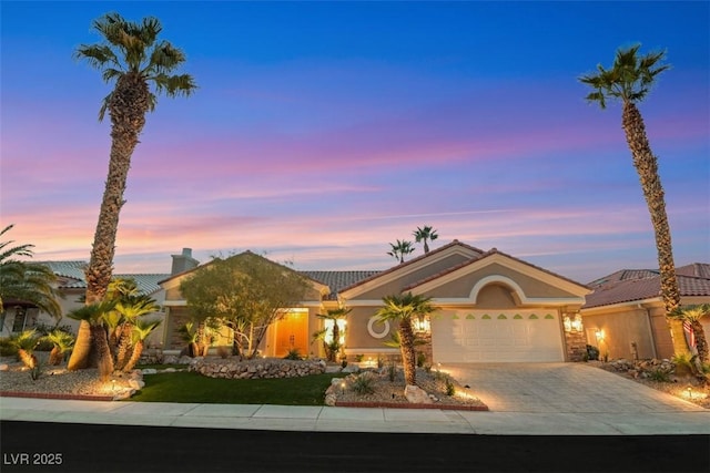 view of front facade featuring a garage, driveway, and stucco siding