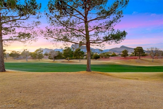 view of community featuring a yard, a mountain view, and view of golf course