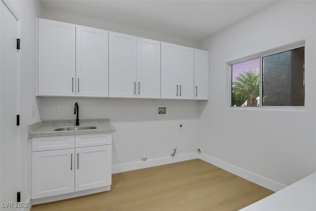 laundry room with hookup for a washing machine, hookup for a gas dryer, cabinet space, a sink, and baseboards