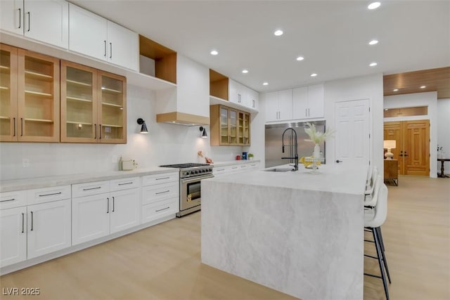 kitchen featuring open shelves, recessed lighting, stainless steel stove, light wood-style floors, and a sink