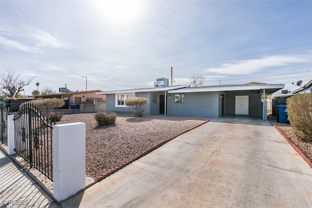 single story home with driveway, an attached carport, cooling unit, and fence