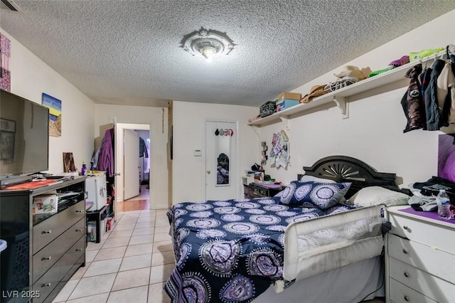 bedroom with light tile patterned floors and a textured ceiling