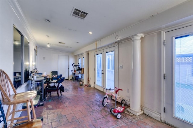 dining room with decorative columns, visible vents, stone finish flooring, crown molding, and french doors