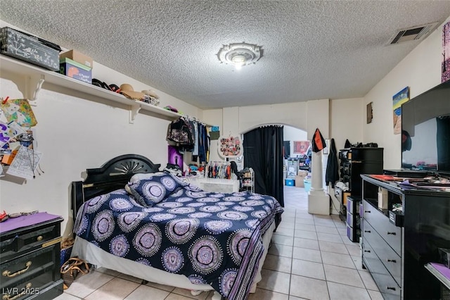 bedroom featuring visible vents, a textured ceiling, and light tile patterned flooring