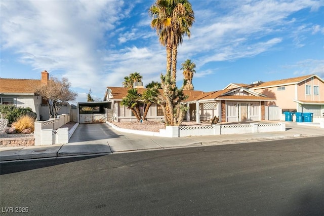 view of front of property featuring driveway, a gate, fence, and a carport