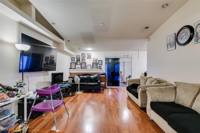 living room with a textured ceiling and wood finished floors