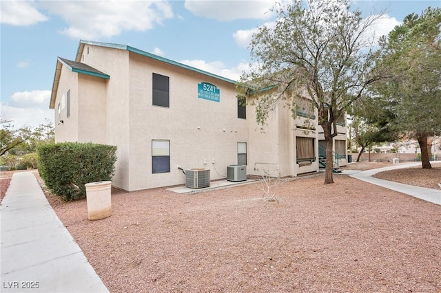 view of side of property featuring cooling unit and stucco siding