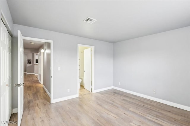 unfurnished bedroom with a closet, visible vents, light wood-style floors, connected bathroom, and baseboards