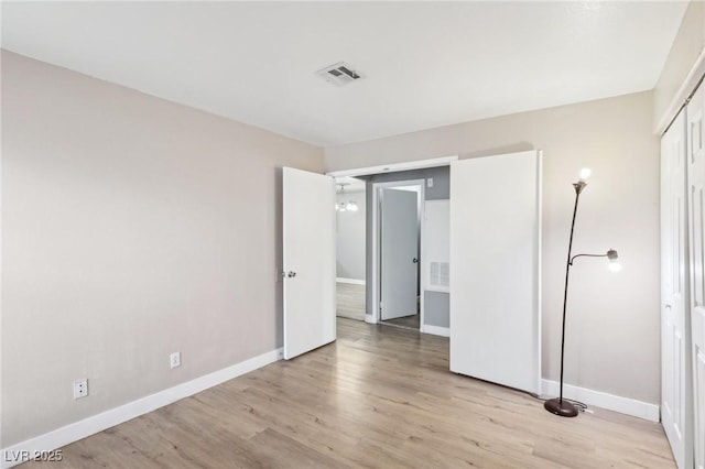 unfurnished bedroom featuring a closet, baseboards, visible vents, and light wood finished floors