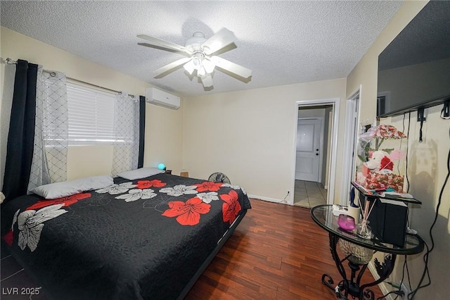 bedroom featuring a ceiling fan, a textured ceiling, wood finished floors, a wall mounted air conditioner, and baseboards