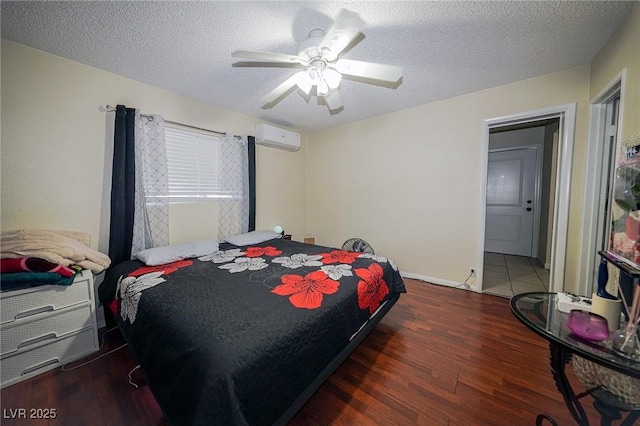 bedroom featuring ceiling fan, a textured ceiling, an AC wall unit, and wood finished floors