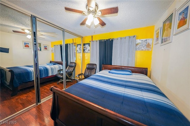 bedroom featuring a closet, a textured ceiling, ceiling fan, and wood finished floors