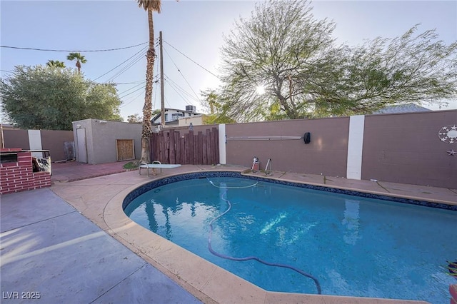 view of pool with a patio area, a fenced backyard, a diving board, and a fenced in pool