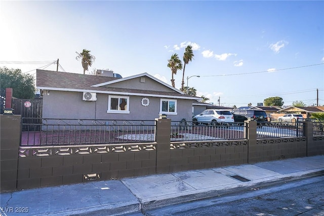 single story home featuring a fenced front yard, concrete driveway, and stucco siding