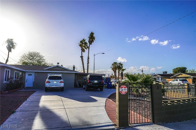 ranch-style home featuring driveway, fence, and a gate