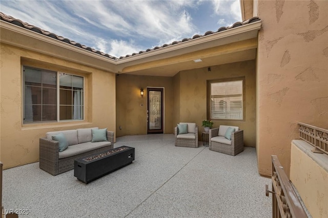 view of patio with an outdoor living space with a fire pit